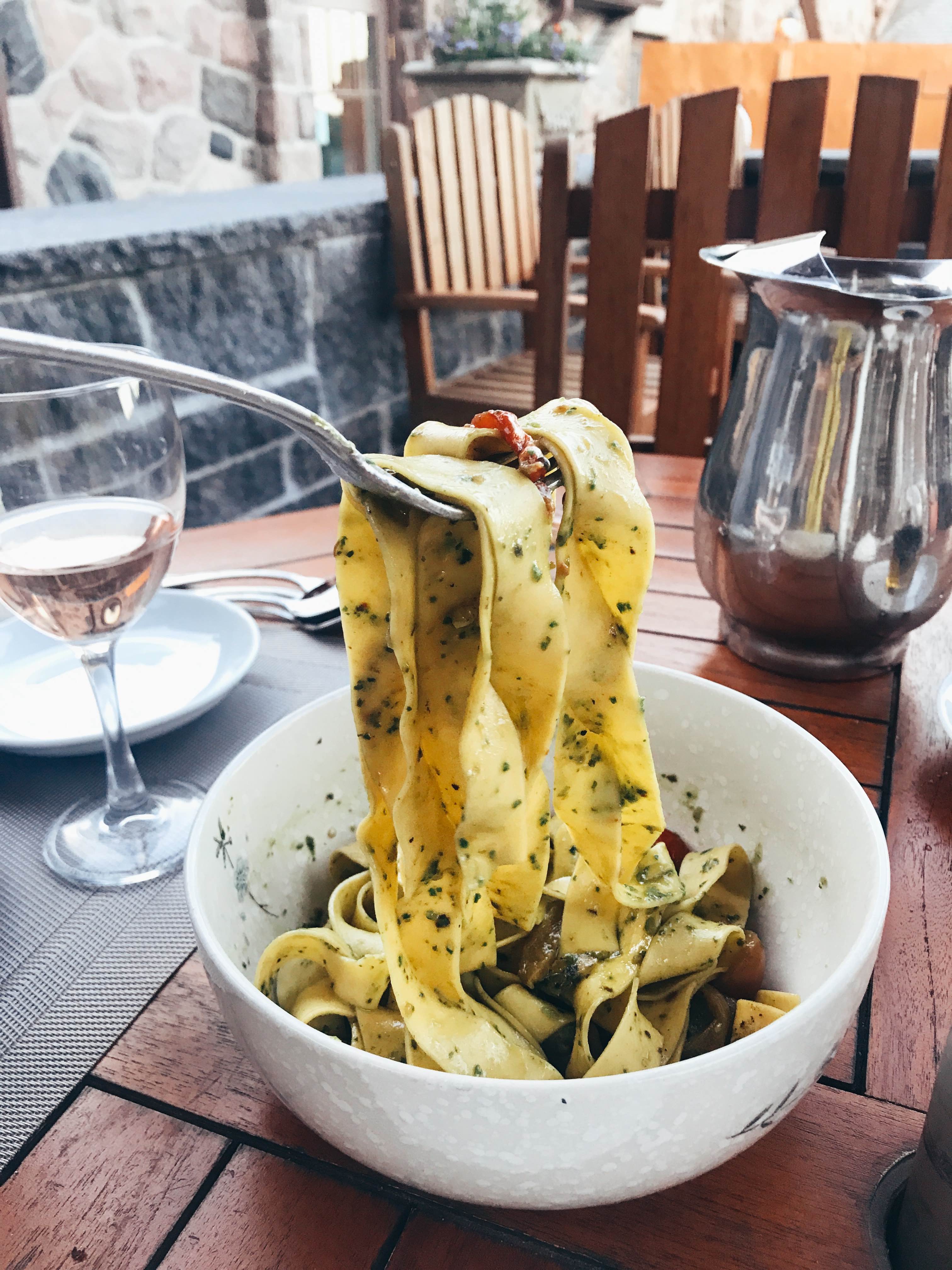 pasta from ste annes spa restaurant in a white bowl being held up by a fork